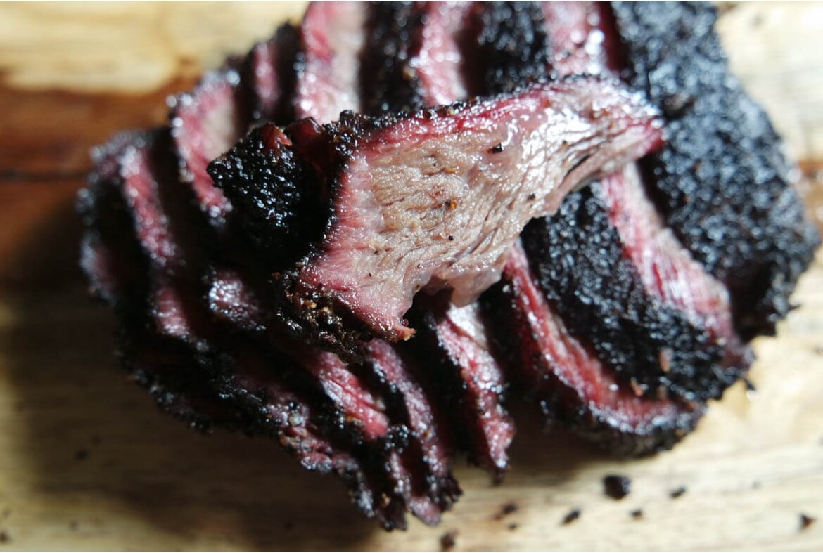 Representative sliced smoked beef cheeks with dark bark and smoke ring